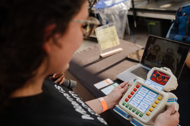 Visitor interacting with Alphie's buttons to request poetry