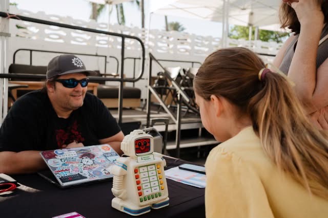 Mario demonstrating Alphie to a young visitor at an O, Miami event