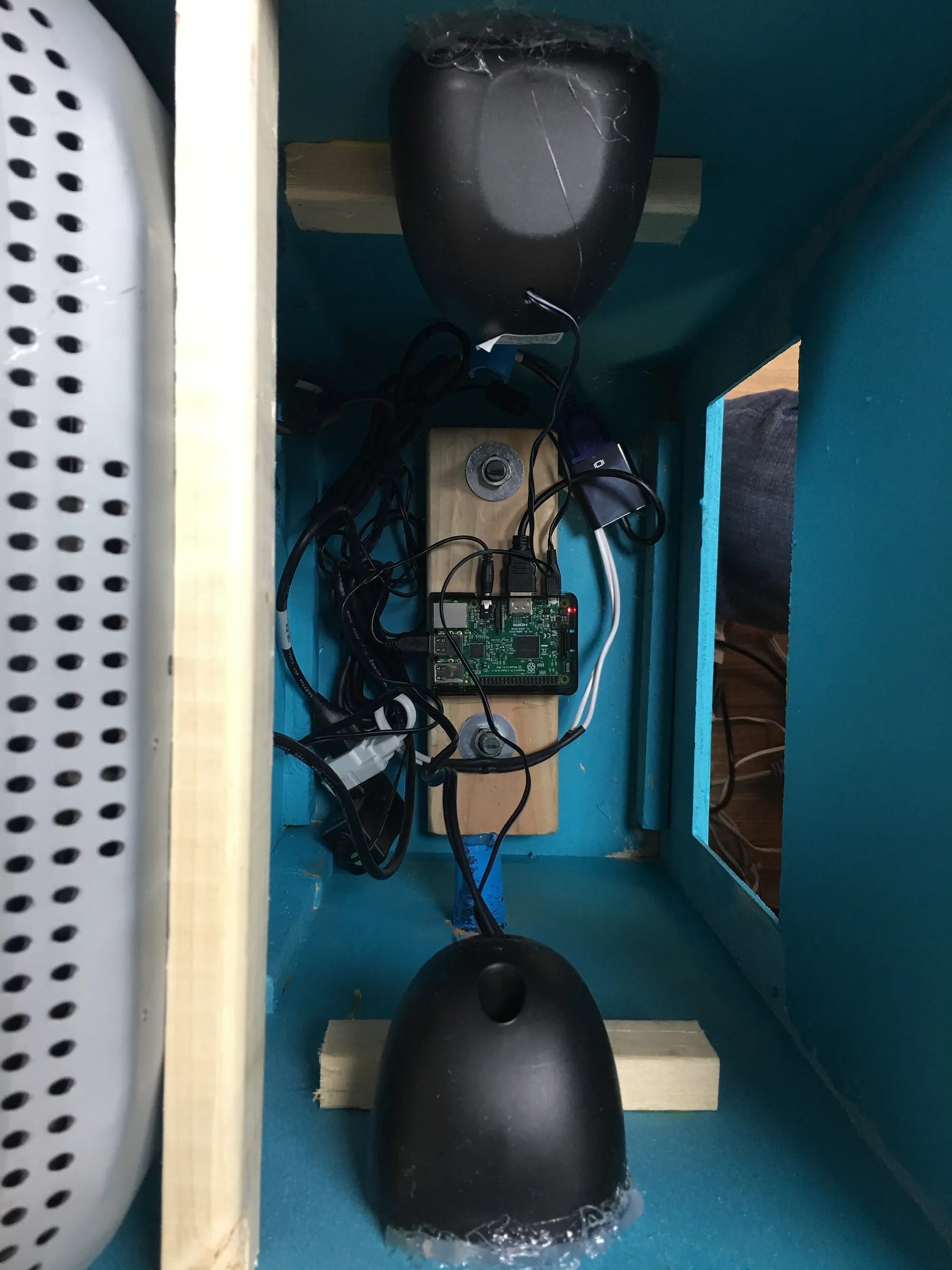 Inside view of the BMO cabinet with a Raspberry Pi and two speaker domes mounted