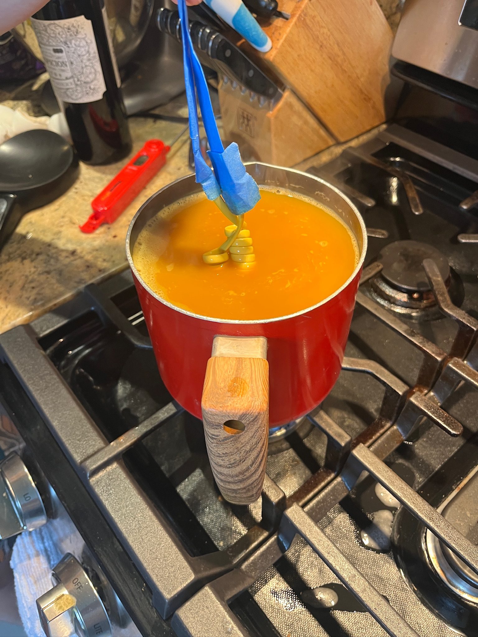 Phone coiled cord being dyed yellow in a pot on the stove